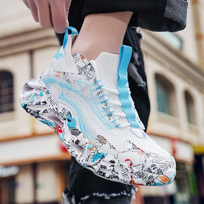 Colorful sneaker with a white base, blue accents, and cartoon-style doodle patterns covering the sole and parts of the upper.