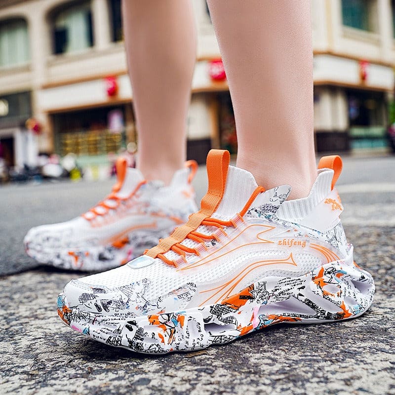 Stylish sneaker with a white and orange design featuring graffiti-like patterns on the sole and upper.