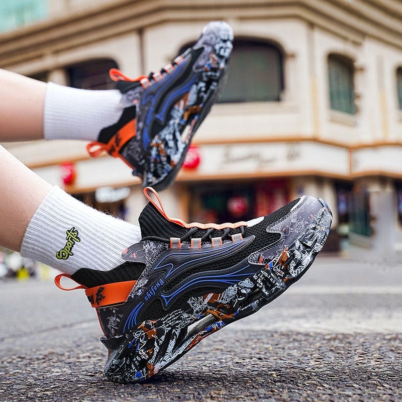 Colorful, chunky sneaker with a graffiti-style pattern and orange accents held by a hand wearing a white sock.