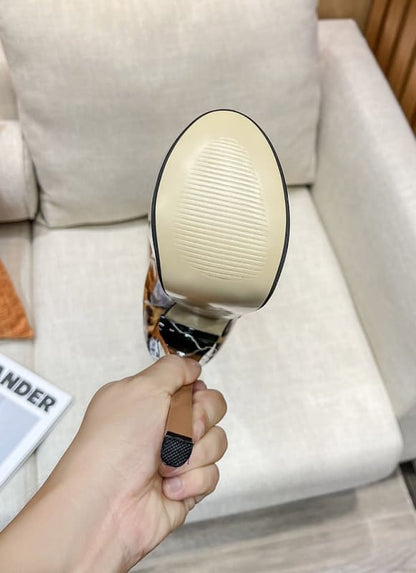 Hand-held magnifying glass with a round lens and metal handle.