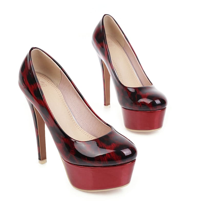 Pair of glossy red and black high-heeled platform shoes.