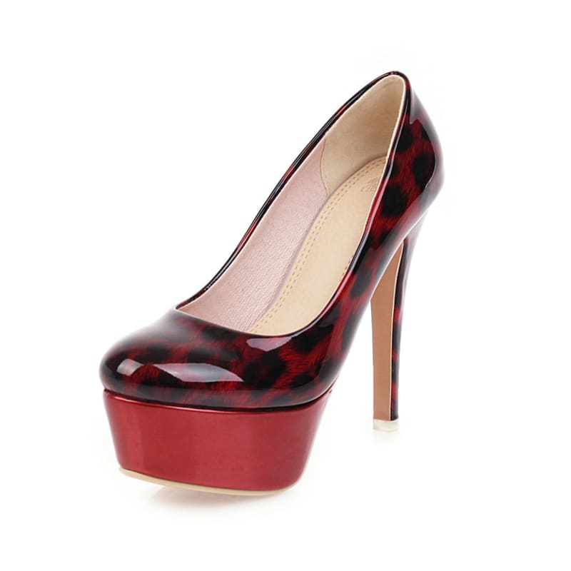 High-heeled platform pump in a glossy red and black tortoiseshell pattern.