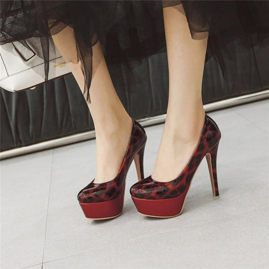 Pair of high-heeled platform shoes with a red and black leopard print design.