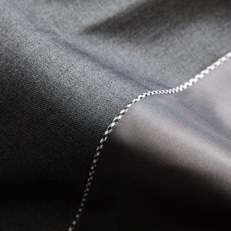 Seam joining two pieces of dark fabric or leather material.