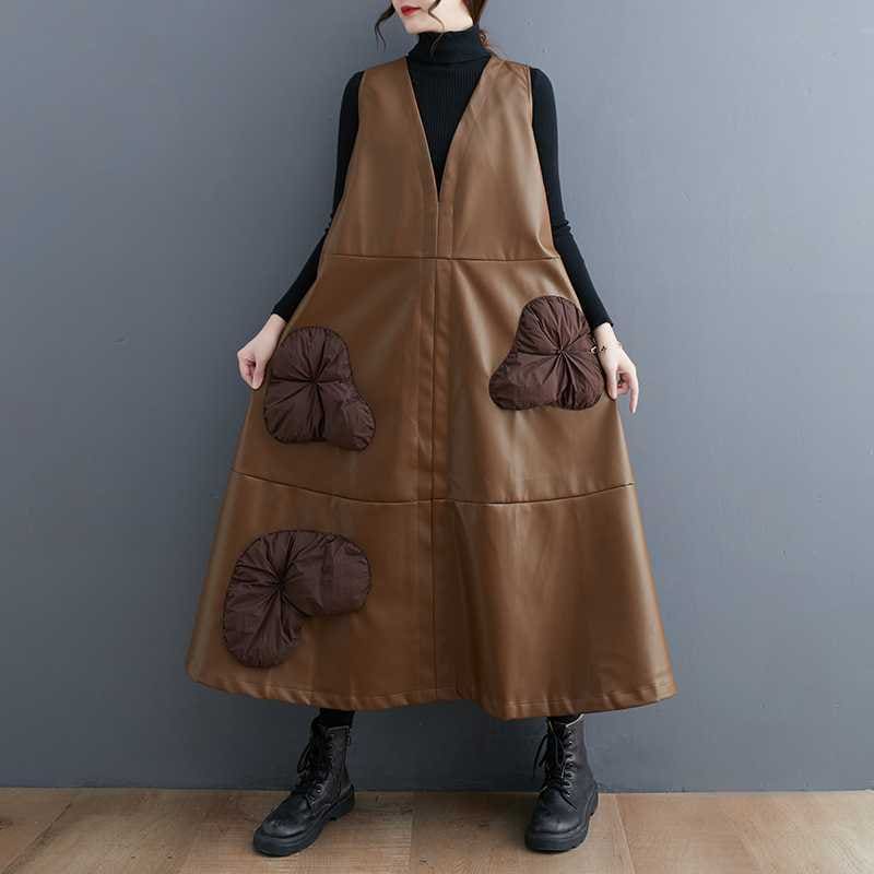 Brown sleeveless dress with decorative flower-shaped pockets worn over a black turtleneck.