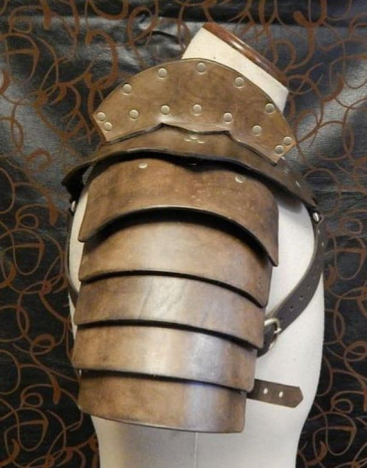 Medieval-style shoulder armor made of overlapping metal plates with rivets.