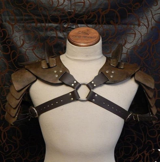 Leather and metal shoulder armor with chest harness on a mannequin torso.