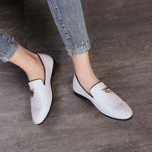 Glittery white loafers with gold hardware on the upper.