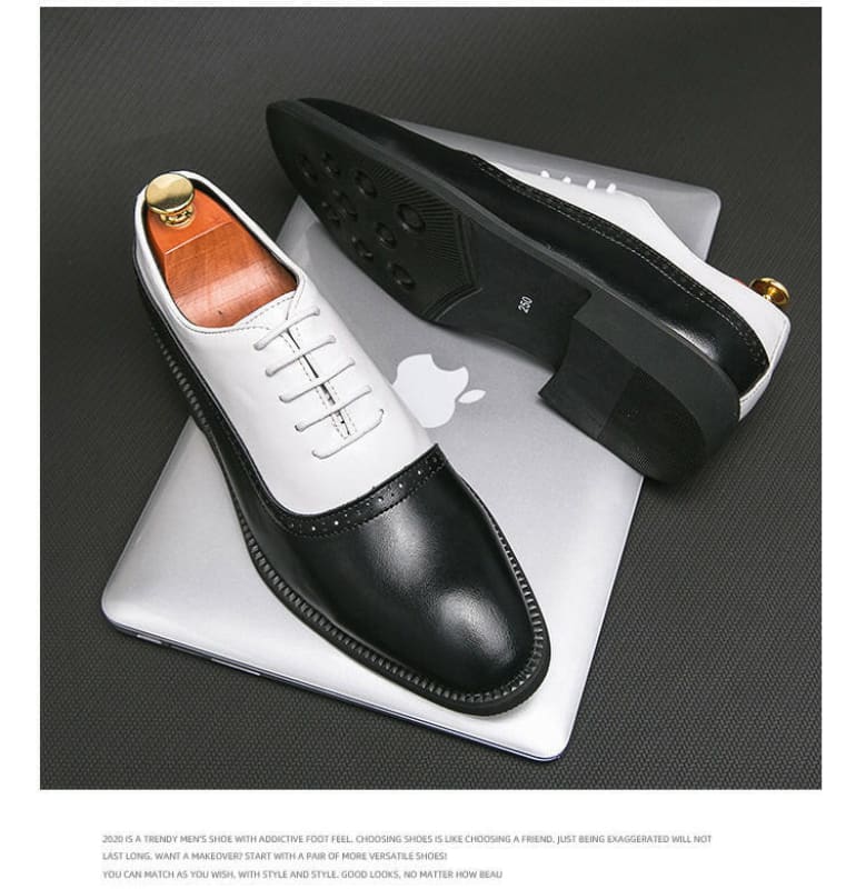 Two-tone leather oxford dress shoes with black toe caps and white uppers.