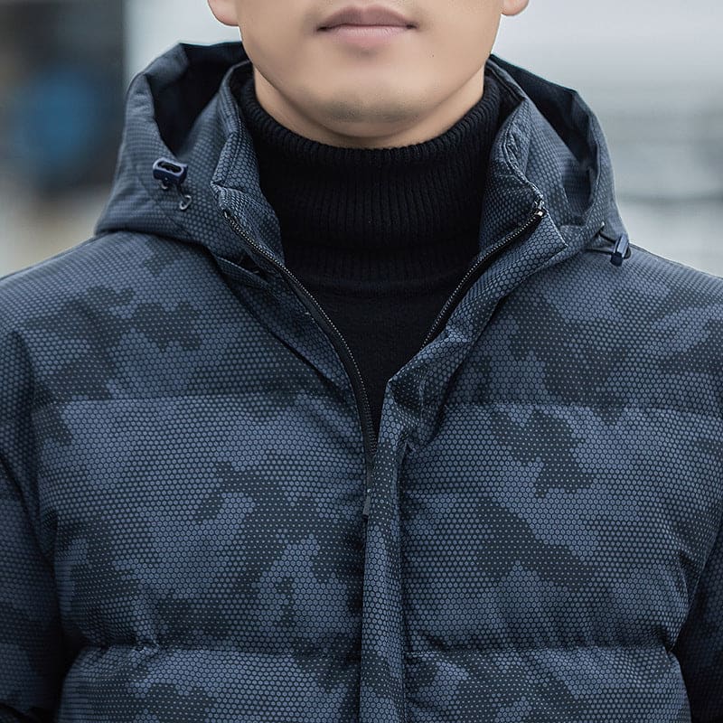 Dark gray puffer jacket with a high collar and black sweater underneath.