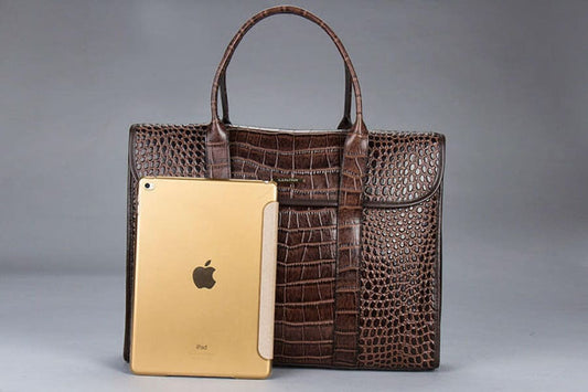 Brown crocodile-textured leather handbag with handles.