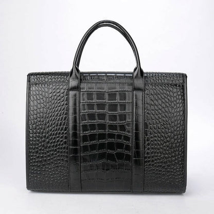 Black leather briefcase with crocodile-textured panels and handles.