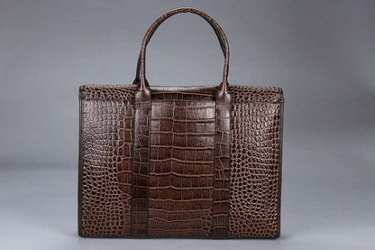 Brown leather handbag with a crocodile skin pattern.