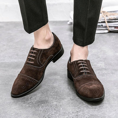 Pair of brown suede oxford shoes with brogue detailing.