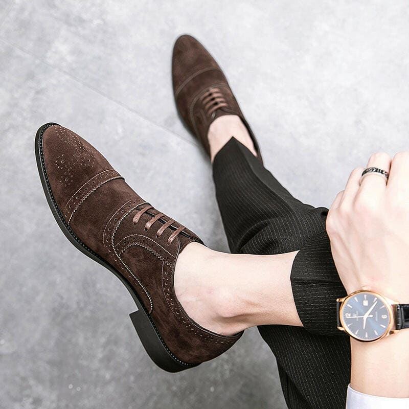 Pair of brown suede oxford shoes with brogue detailing.