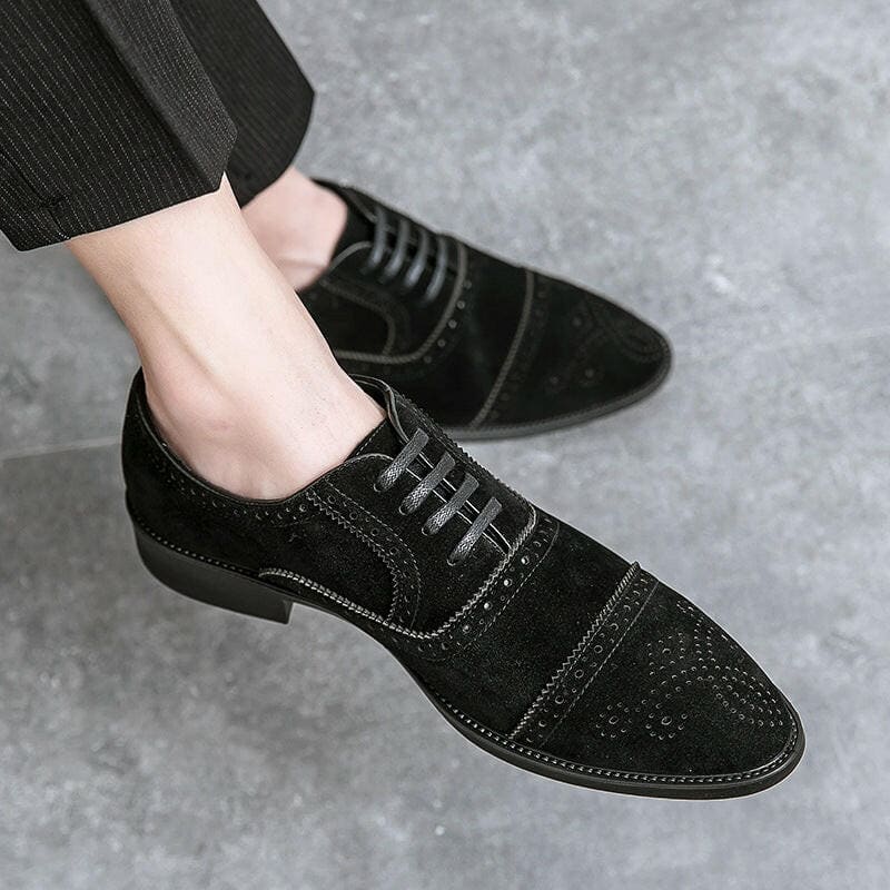 Black suede oxford shoe with decorative perforations on the toe cap.