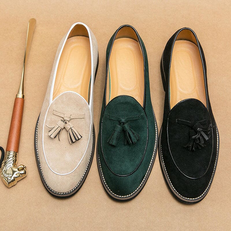 Three suede loafers with tassels in beige, dark green, and black colors.