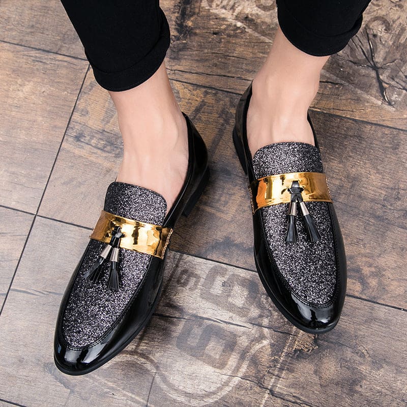 Glittery black loafers with gold accents and tassels.