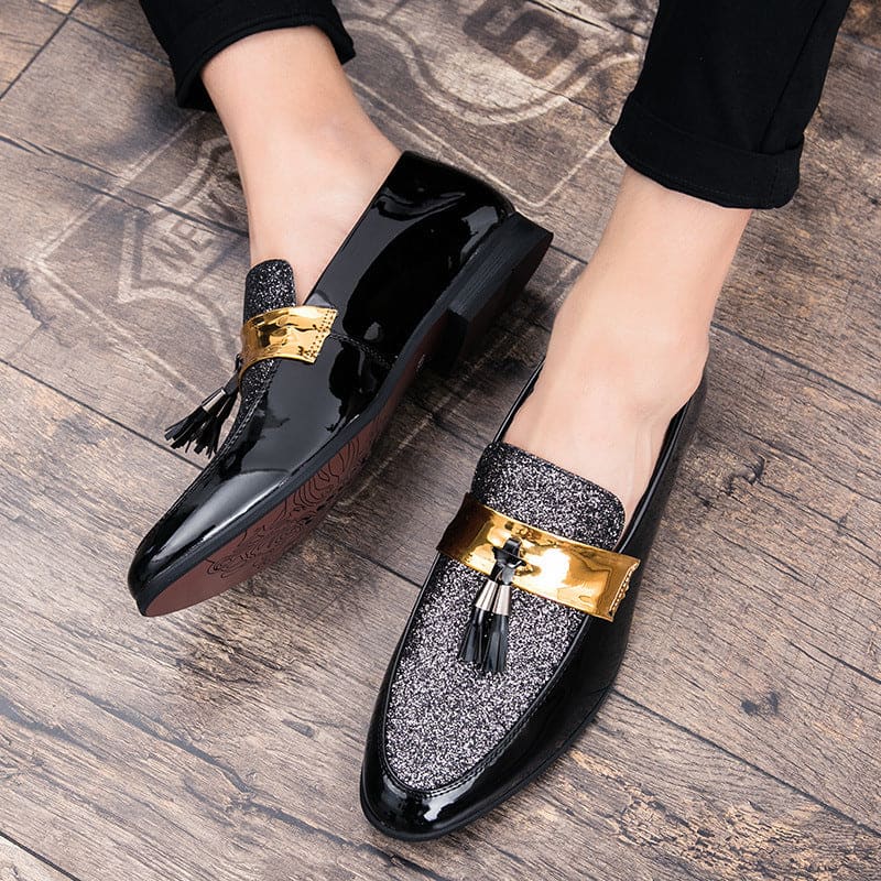 Stylish men’s loafers with glittery fabric, gold accents, and tassels.