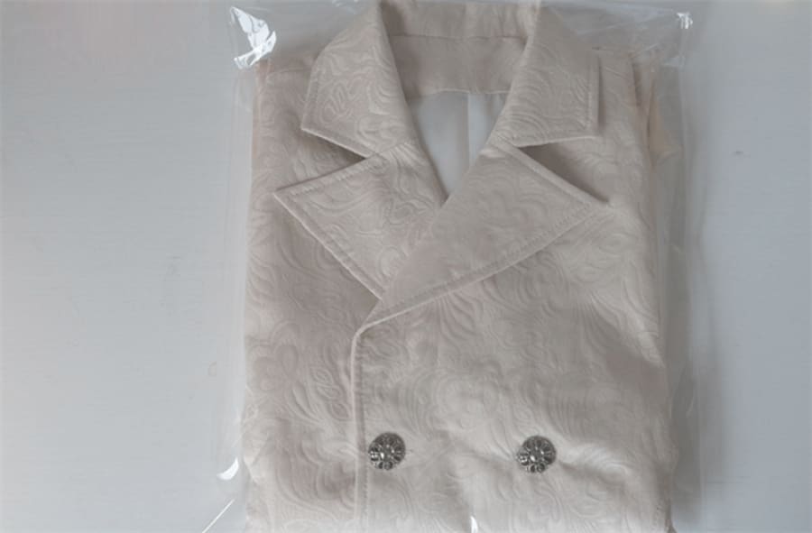 Beige suit jacket wrapped in clear plastic packaging.