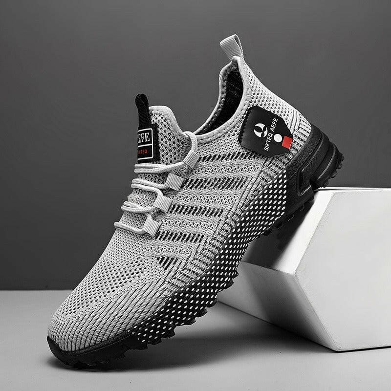 Athletic sneaker with a mesh upper and black sole, featuring a gray and white color scheme.