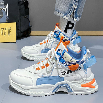 Chunky white sneakers with blue and orange accents and decorative attachments.