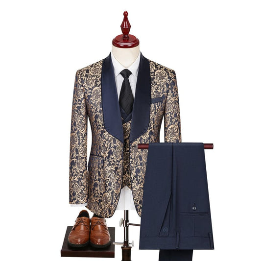 Ornate floral patterned suit jacket with navy lapels, matching vest, and navy trousers, accompanied by a tie and brown dress shoes.