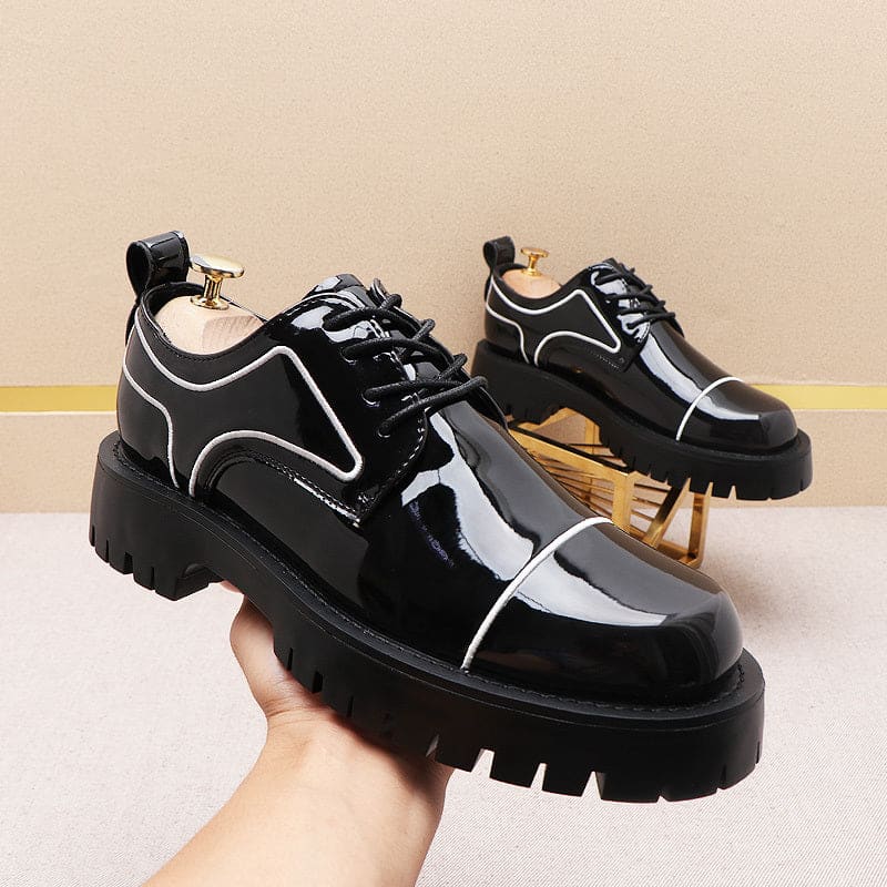 Chunky black patent leather platform shoes with white trim and thick soles.