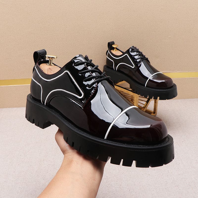 Chunky black patent leather platform shoes with white trim and thick soles.