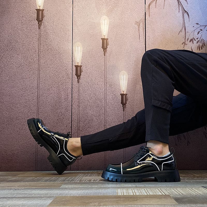 Chunky black sneakers with neon green accents worn by a person sitting.