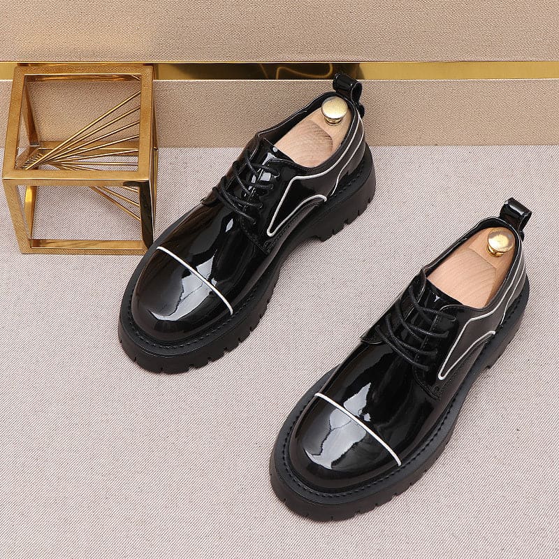 Pair of glossy black lace-up shoes with thick soles and white trim details.