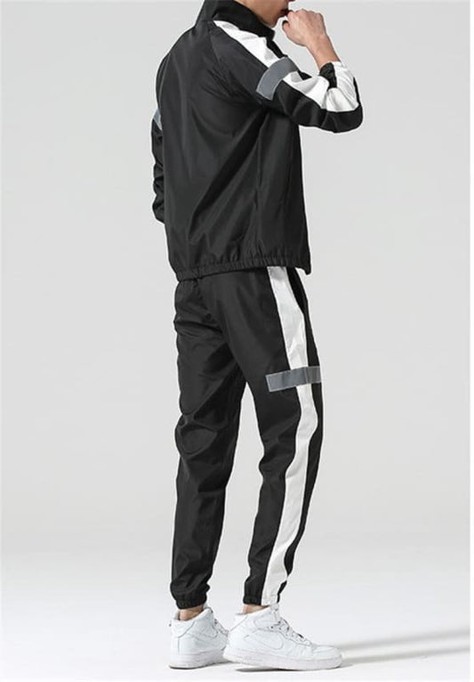 Tracksuit with black base and white side stripes on jacket and pants.