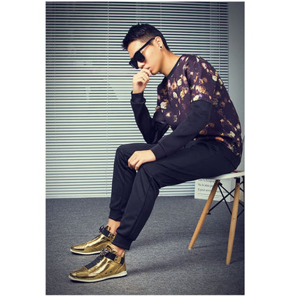 Stylishly dressed person sitting on a chair wearing sunglasses and gold shoes.