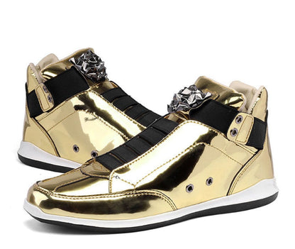 Metallic gold high-top sneakers with black accents and decorative metal embellishments.