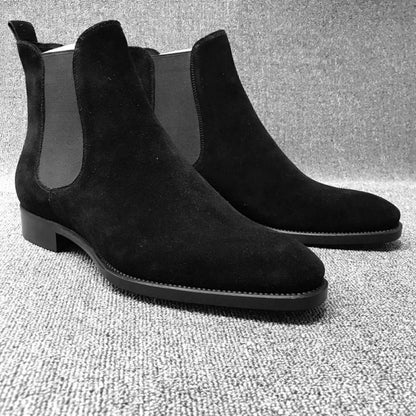 Pair of black suede Chelsea boots with elastic side panels.