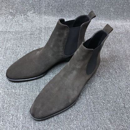 Pair of gray suede Chelsea boots with elastic side panels.