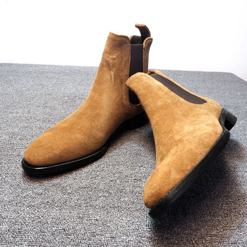 Pair of tan suede Chelsea boots with elastic side panels.