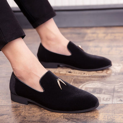 Black suede loafers with a small metal tassel detail on the vamp.