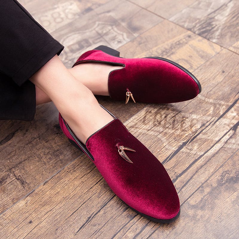 Pair of burgundy velvet loafers with small gold embellishments.