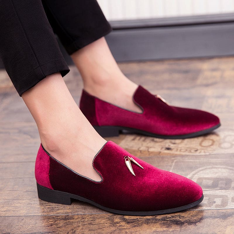 Pair of deep red velvet loafers with small metal accents on the vamp.