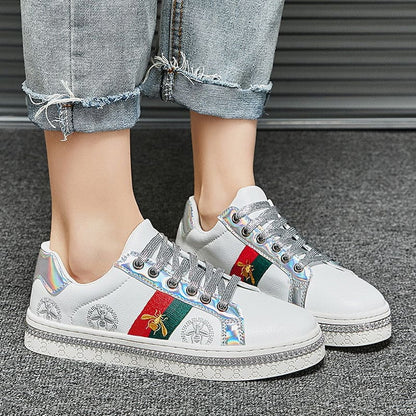 White sneakers with colorful decorative stripes and embellishments.