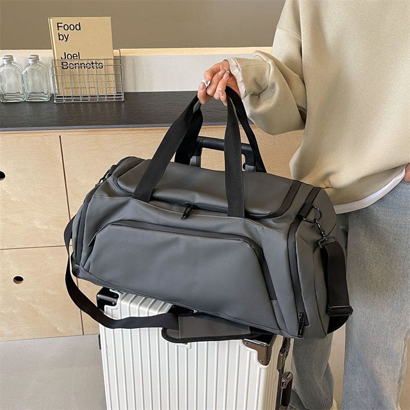 Gray duffel bag with multiple compartments and carrying straps.