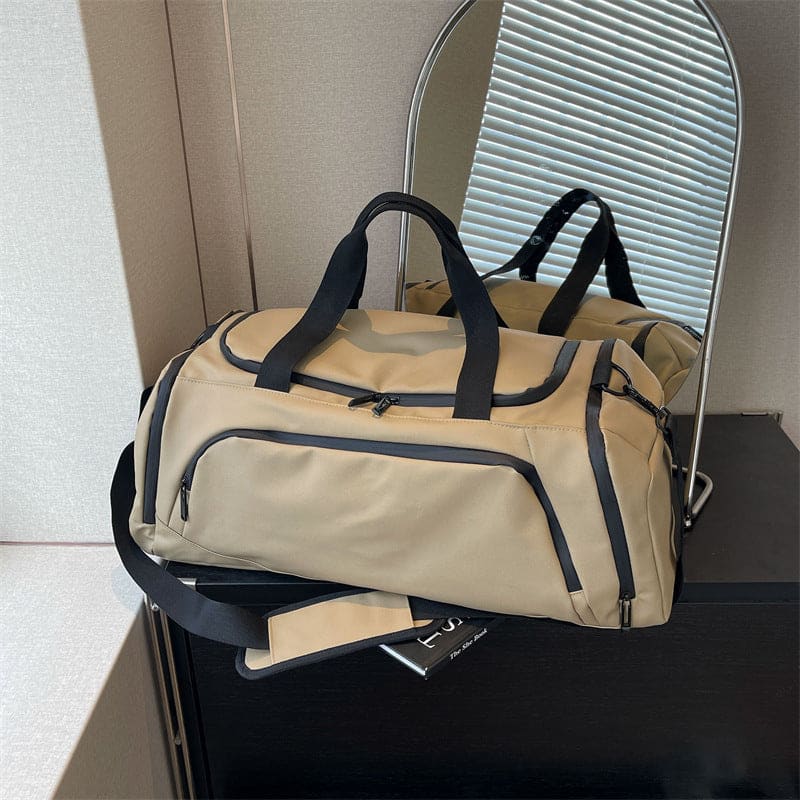 Beige duffel bag with black straps and zippers.