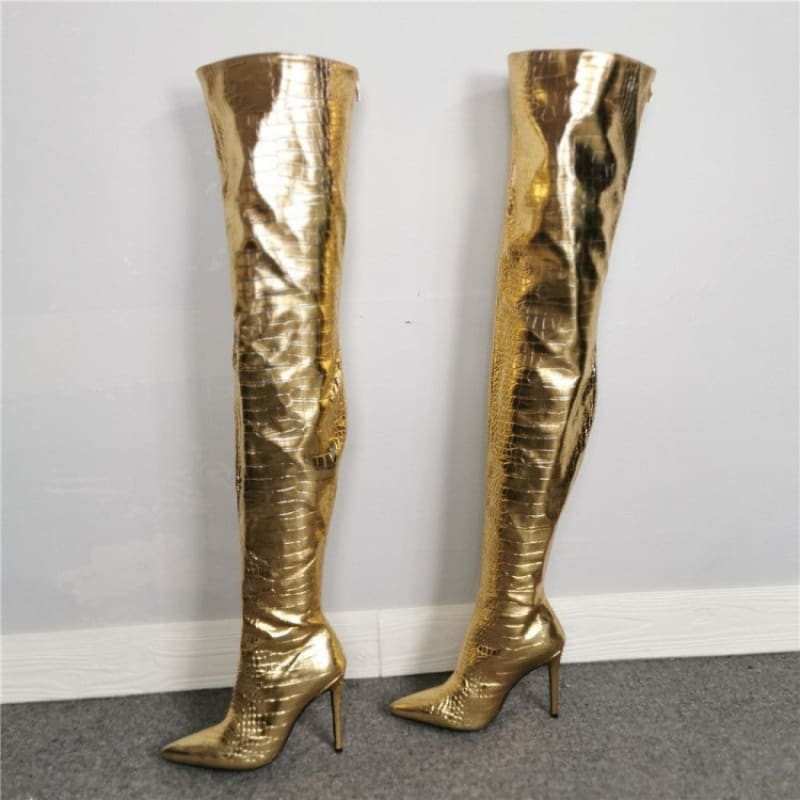 Pair of shiny gold thigh-high stiletto boots.