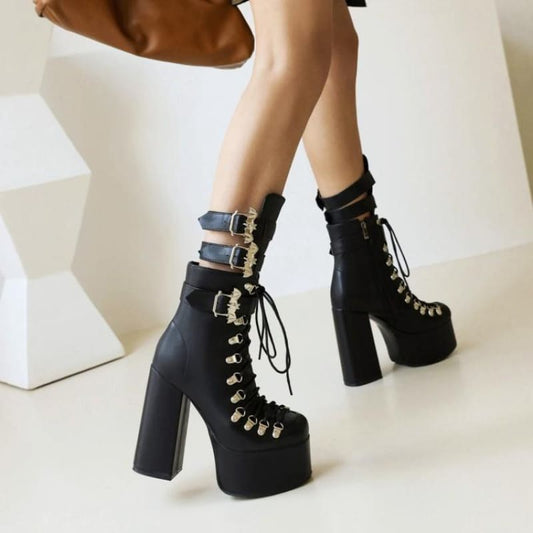 Pair of black platform ankle boots with chunky heels, laces, and silver buckle straps.