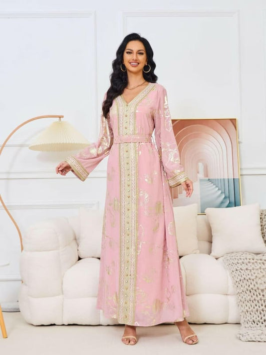 Long pink kaftan-style dress with gold embroidery and long sleeves.