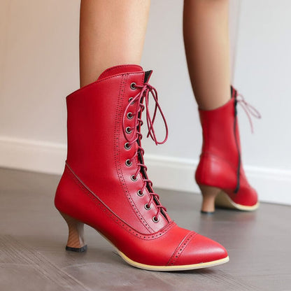 Pair of bright red lace-up ankle boots with pointed toes and slender heels.