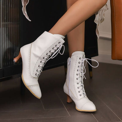 White lace-up high-heeled ankle boots with pointed toes.