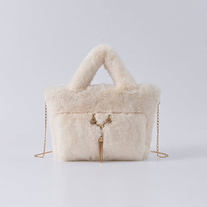 Fluffy white handbag with gold chain straps and tassel detail.