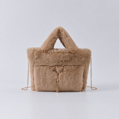 Fluffy beige handbag with a chain strap and decorative tassel.